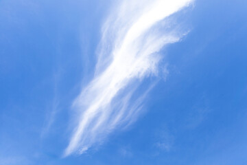 Gentle, dreamy clouds form abstract patterns across a calm blue sky, evoking peace, imagination,...