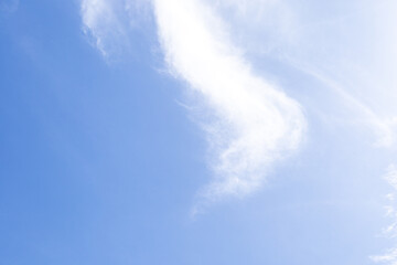 Gentle, dreamy clouds form abstract patterns across a calm blue sky, evoking peace, imagination,...