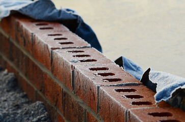 Close-up of red brick wall top covered with frost and on a cold winter day