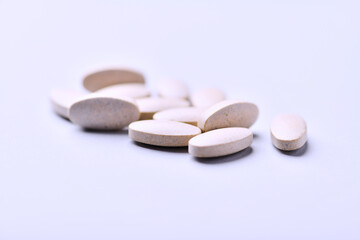 Ashwagandha (Withania somnifera) tablets on paper background. Soft focus. Close up. Copy space.	