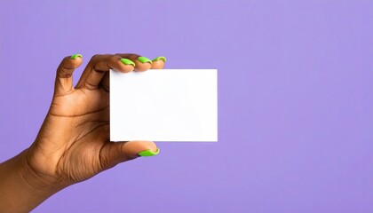 Hand holding blank white card against purple background