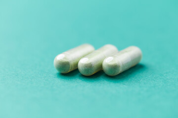 Barley grass capsules. Antioxidants. Concept for a healthy dietary supplementation. Bright background. Soft focus. Close up. Copy space.	