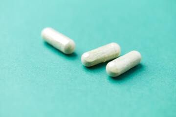 Barley grass capsules. Antioxidants. Concept for a healthy dietary supplementation. Bright background. Soft focus. Close up. Copy space.	