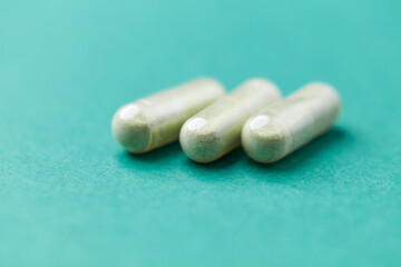 Barley grass capsules. Antioxidants. Concept for a healthy dietary supplementation. Bright background. Soft focus. Close up. Copy space.	