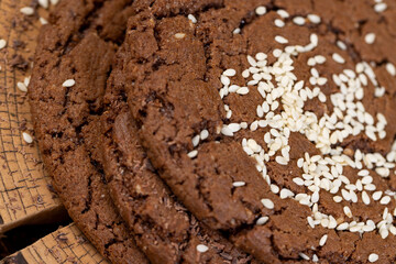 chocolate-flavored biscuits with sesame seeds on the table, closeup