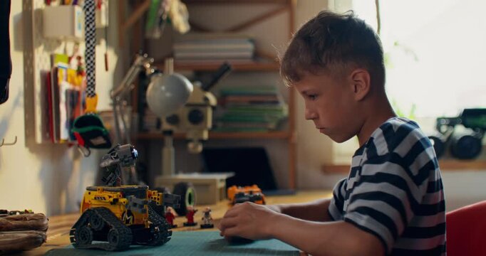 A boy builds a robot out of a construction kit and controls it with a joystick