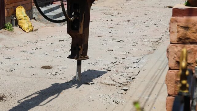 digger machine breaking road for new construction in daylight