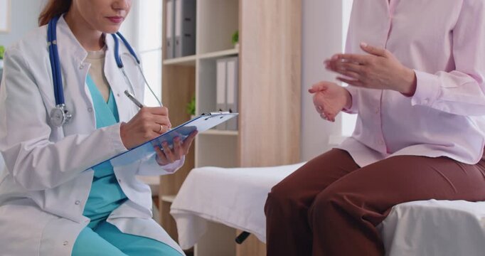 Doctor, wearing lab coat and stethoscope, holding clipboard, conversation with patient sitting opposite, focused medical consultation, discussing health matters, professional guidance, attentive care