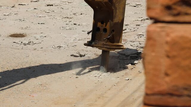 excavator tearing road surface for construction work at day