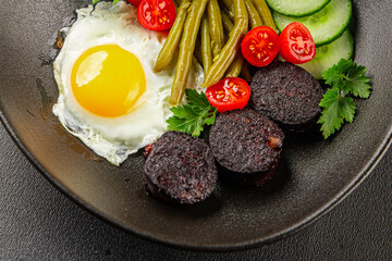 English breakfast fried egg, black pudding, vegetables, beans fresh delicious gourmet food background on the table rustic food top view copy space