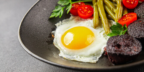 English breakfast fried egg, black pudding, vegetables, beans fresh delicious gourmet food background on the table rustic food top view copy space