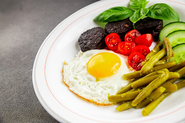 English breakfast fried egg, black pudding, vegetables, beans fresh delicious gourmet food background on the table rustic food top view copy space