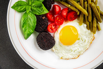 English breakfast fried egg, black pudding, vegetables, beans fresh delicious gourmet food background on the table rustic food top view copy space