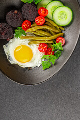 English breakfast fried egg, black pudding, vegetables, beans fresh delicious gourmet food background on the table rustic food top view copy space