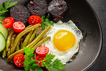 English breakfast fried egg, black pudding, vegetables, beans fresh delicious gourmet food background on the table rustic food top view copy space