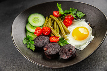 English breakfast fried egg, black pudding, vegetables, beans fresh delicious gourmet food background on the table rustic food top view copy space