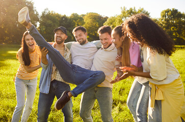 Overjoyed friends having fun and laughing while posing in park, have carefree happy expressions,...