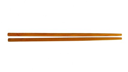A pair of wooden chopsticks placed on a white background. Two wooden chopsticks made of wood. Wooden chopsticks are tools for eating. Wooden chopsticks. Viewed from above.