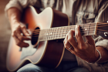 Fototapeta premium Close-up of hands playing a guitar, with a shallow depth of field and a musical background.