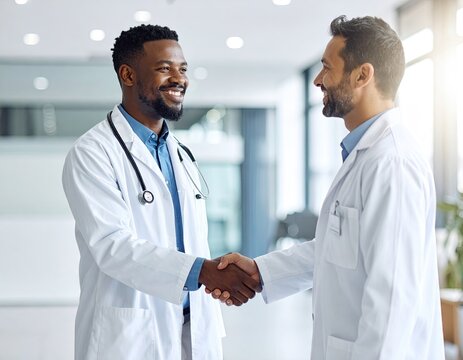 Two doctors shaking hands in a hospital hallway - Powered by Adobe