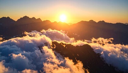 Sunrise over mountain peaks shrouded in clouds