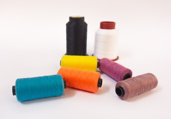 Hilos de costura coloridos sobre fondo blanco