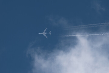 passenger aircraft flying at cruising altitude with blue sky and clouds