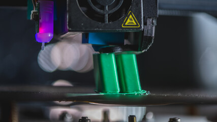 Modern 3d printer creating a green plastic object using innovative technology in a laboratory setting, showcasing the advancements in additive manufacturing