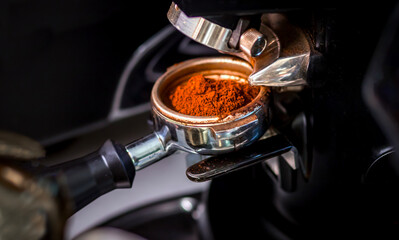Freshly ground coffee in a portafilter, ready for brewing in a professional espresso machine. Close-up barista equipment concept for café culture and coffee lovers.
