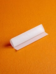 Single Rolling Paper on Orange Background - Selective Focus