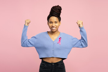 Smiling, happy African American woman showing strength and support for breast cancer awareness
