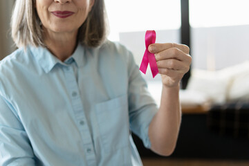 Woman showing pink ribbon supporting breast cancer awareness campaign