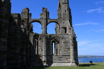 Whitby Abbey, an ancient ruin located in Yorkshire, UK, sits under a clear blue sky at Whitby Abbey...