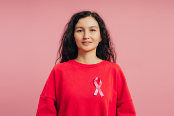 Young woman wearing pink ribbon showing support for breast cancer awareness