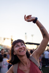 girl at a concert of her favorite music group, dancing and smiling from happiness, celebration and...
