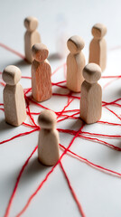 Obraz premium Wooden figures connected by red threads people connection