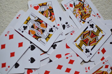 Playing cards, the deck is scattered chaotically on the floor.	