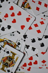 Playing cards, the deck is scattered chaotically on the floor.	