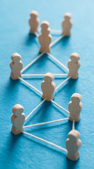 Obraz premium Wooden figures connected by white threads forming a network blue background