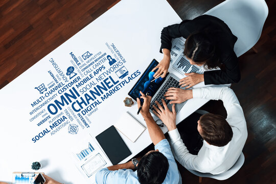 Aerial view of business professionals working together on omni-channel marketing strategies in a modern workspace, showcasing data analysis tools and collaborative environment. Amity