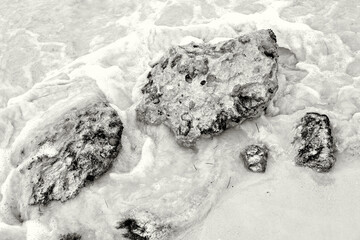 Water Swirling Around Stones on the Beach