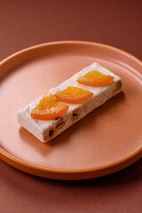 Nougat or white caramel with hazelnuts and pistachios and citrus pieces. White nougat with nuts