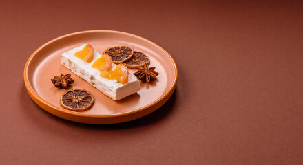 Nougat or white caramel with hazelnuts and pistachios and citrus pieces. White nougat with nuts
