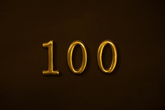 yellow gold golden  one hundred 100 Number Write isolated On black Dark Wall door Background. white 100 Number Logo.