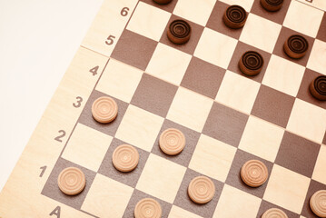 Wooden checkers on the board. The board game checkers.