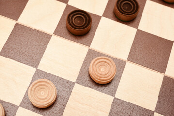 Wooden checkers on the board. The board game checkers.