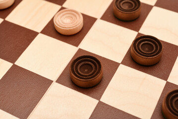 Wooden checkers on the board. The board game checkers.