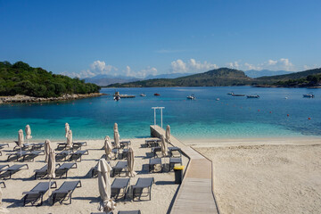 Fototapeta premium beach umbrellas closed during low season on the beach in Ksamil, Albanian rivieira