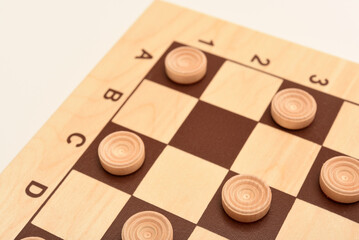 Wooden checkers on the board. The board game checkers.