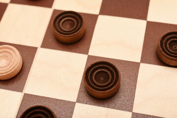 Wooden checkers on the board. The board game checkers.